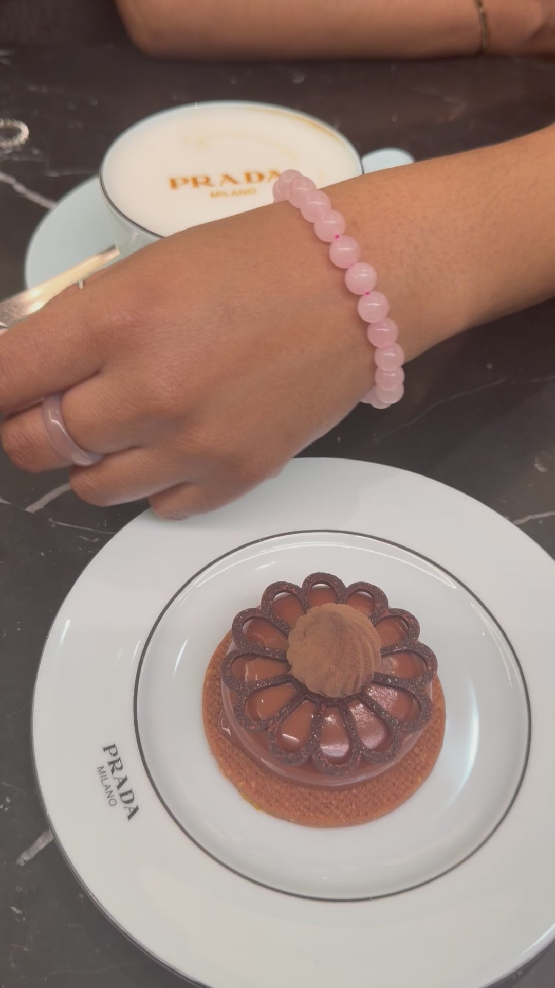 Rose quartz beaded bracelet worn on wrist, soft pink natural stone jewellery in lifestyle setting